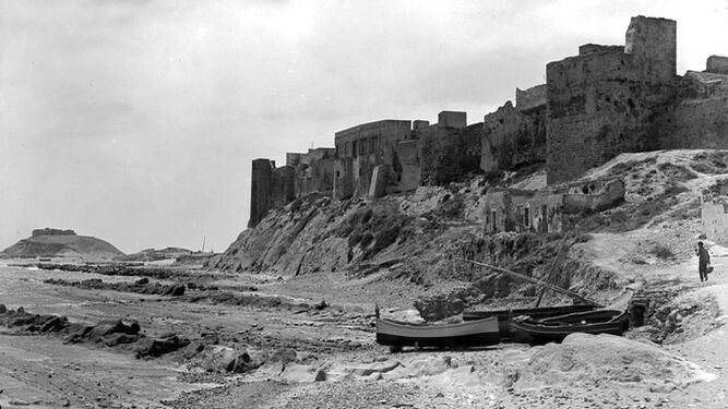 La caleta y el castillo, a comienzos del siglo XX. Se observa lo escarpado del promontorio y el mar llegando a los pies de la roca